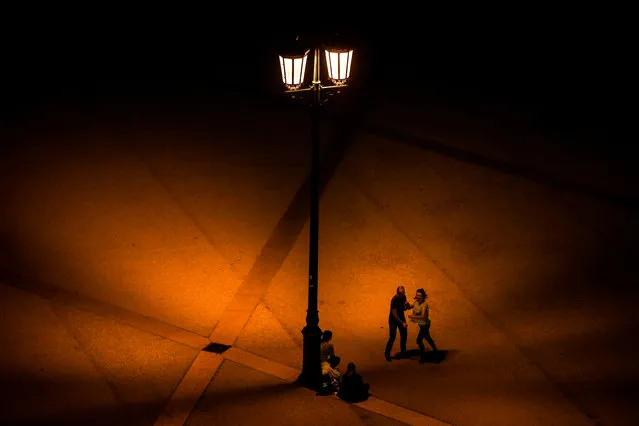 A couple dances under the light of a lamppost at Comercio square in Lisbon, Portugal on December 17, 2018. (Photo by Patrícia de Melo Moreira/AFP Photo)