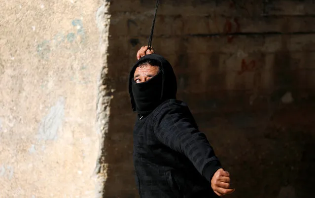 A Palestinian demonstrator uses a sling to hurl stones at Israeli troops during clashes at a protest near the Jewish settlement of Qadomem, in the village of Kofr Qadom near Nablus in the Israeli-occupied West Bank January 4, 2019. (Photo by Mohamad Torokman/Reuters)