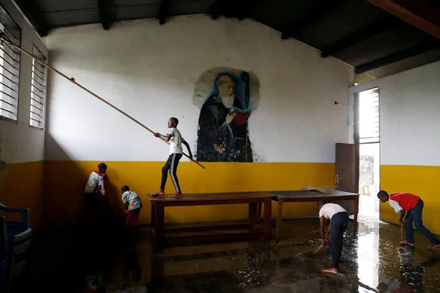 Boys help to clean Saint Benoit church during Christmas day preparations, in Kinshasa, Democratic Republic of Congo, December 24, 2018. (Photo by Baz Ratner/Reuters)