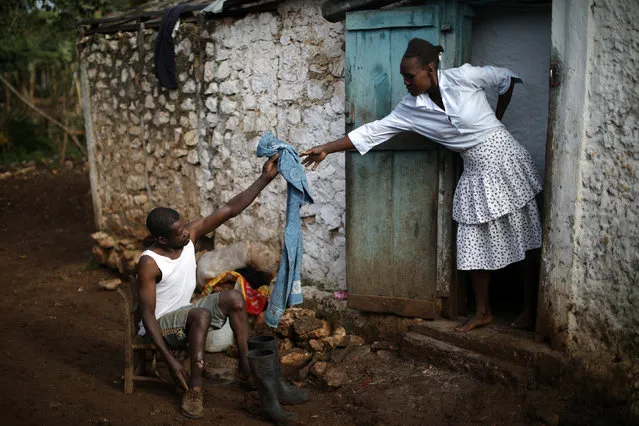 Cristera Jusma hands a towel to Enol St. Pierre as he gets ready to go to the church in Boucan Ferdinand, Haiti, April 8, 2018. (Photo by Andres Martinez Casares/Reuters)