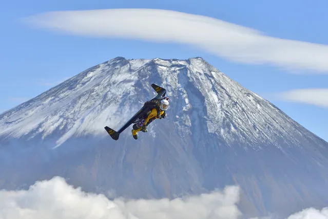 In this photo taken Friday, November 1, 2013 and provided by Breitling, Yves Rossy, known as the Jetman, flies by Mount Fuji in Japan. The Swiss aviator jumped from a helicopter at an altitude of 3,600 meters (11,811 feet) and successfully flew the jet-powered carbon-Kevlar Jetwing around the 3,776-meter (12,388-foot)-tall mountain, Japan's highest peak, which was recognized as a UNESCO World Heritage site in June. (Photo by Katsuhiko Tokunaga/AP Photo/Breitling)