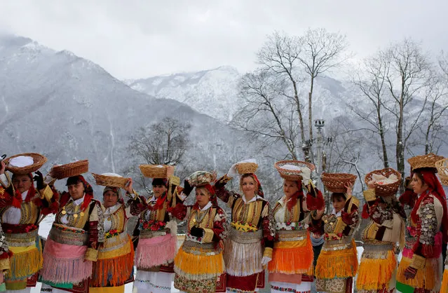 Women dressed in traditional folk costumes balance baskets of bread on their heads during an Epiphany day celebration in Bitushe village, Macedonia January 19, 2017. (Photo by Ognen Teofilovski/Reuters)