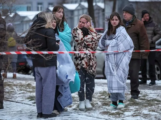 Local residents stand near their apartment building damaged during a Russian missile strike, amid Russia's attack on Ukraine, in Kyiv, Ukraine on January 23, 2024. (Photo by Gleb Garanich/Reuters)