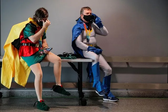 Attendees dressed as Batman and Robin take a break in a hallway during the 2021 New York Comic Con, at the Jacob Javits Convention Center in Manhattan in New York City, New York, U.S., October 7, 2021. (Photo by Brendan McDermid/Reuters)