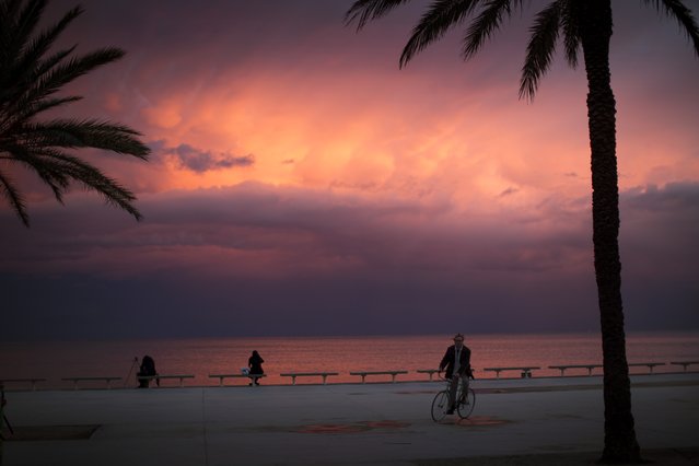 A man rides a bicycle as the sun sets on the Mediterranean coast of Barcelona, Spain, Monday, Feb. 10, 2014. (Photo by Emilio Morenatti/AP Photo)
