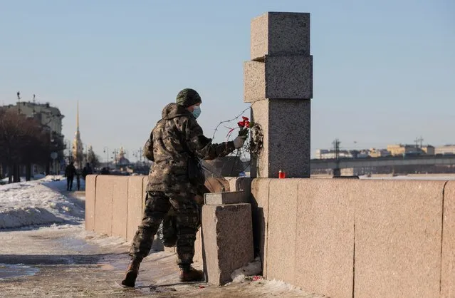A person with a waste bag removes flowers laid in memory of late Russian opposition leader Alexei Navalny at the monument to the victims of political repression in Saint Petersburg, Russia on February 19, 2024. (Photo by Reuters/Stringer)