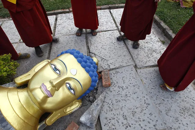 A group of Buddhist monks stands around a damaged statue of Lord Buddha during Buddha's birthday following the deadly earthquake, at a monastery in Kathmandu, Nepal, 04 May 2015. Nepalese Buddhist devotees will not visit Syambhunaath Stupa – a main pilgrimage site on Buddha's birthday, due to safety concerns following the 25 April 7.8-magnitude earthquake. (Photo by Narendra Shrestha/EPA)