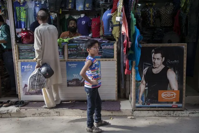 A photograph of Bollywood actor Salman Khan, right, part of an advertisement poster is displayed at a cloth store in New Delhi, India, Wednesday, May 6, 2015. One of India's biggest and most popular movie stars, Salman Khan, was sentenced to five years in jail Wednesday on charges of running over five men sleeping on a sidewalk and killing one in a hit-and-run case that has dragged for more than 12 years. (Photo by Tsering Topgyal/AP Photo)