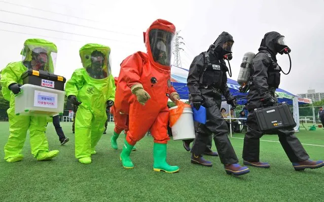 South Korean rescue members wearing chemical protective suits participate in an anti-terror drill as part of a countrywide civilian-military defence exercise called “Ulchi Taeguk Exercise” in Seoul on May 27, 2019. South Korea kicked off on May 27, a new civilian-military exercise for four days aimed at preparing for a range of contingencies including disasters and terror threats. (Photo by Jung Yeon-je/AFP Photo)