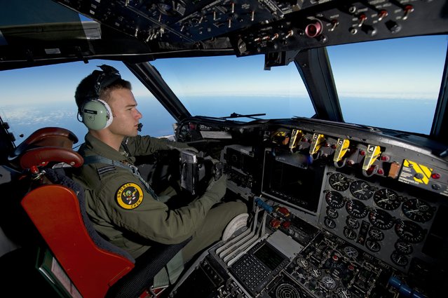 A handout picture made available by the Australian Department of Defense on 20 March 2014 shows Royal Australian Air Force pilot, Flight Lieutenant Russell Adams from the tenth Squadron, steering his AP-3C Orion over the Southern Indian Ocean during the search for missing Malaysian Airlines flight MH370. A Royal Australian Air Force (RAAF) AP-3C Orion maritime patrol aircraft from ten Squadron, 92 Wing conducted a search operation for missing Malaysia Airlines Flight MH370 in the southern Indian Ocean on 19 March 2014. (Photo by Sergeant Hamish Paterson/EPA/Australian Government Dep Of Defense)