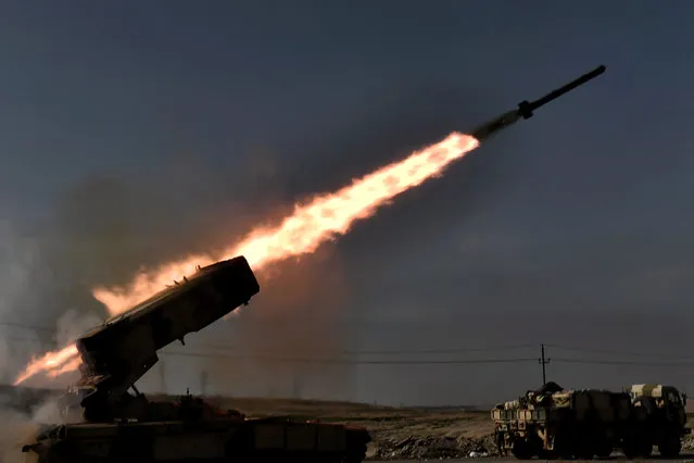 Iraqi troops fire a missile towards Islamic State (IS) group fighters from the outskirts of Mosul as Iraqi forces battle against the group to recapture the west of the city on February 28, 2017. Hundreds of civilians fled through the desert to escape fighting and privation in Mosul, joining thousands of others who left their homes as conditions worsen in the city's west. (Photo by Aris Messinis/AFP Photo)