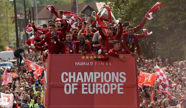 Liverpool's Spanish defender Alberto Moreno (3R) holds aloft the European Champion Clubs' Cup trophy as he stand with teammates (LtoR) Liverpool's English midfielder James Milner, Liverpool's Scottish defender Andrew Robertson, Liverpool's English midfielder Jordan Henderson, Liverpool's English midfielder Alex Oxlade-Chamberlain, Liverpool's Dutch midfielder Georginio Wijnaldum, Liverpool's English striker Daniel Sturridge and Liverpool's English defender Trent Alexander-Arnold during an open-top bus parade around Liverpool, north-west England on June 2, 2019, after winning the UEFA Champions League final football match between Liverpool and Tottenham. Liverpool's celebrations stretched long into the night after they became six-time European champions with goals from Mohamed Salah and Divock Origi to beat Tottenham – and the party was set to move to England on Sunday where tens of thousands of fans awaited the team's return. The 2-0 win in the sweltering Metropolitano Stadium delivered a first trophy in seven years for Liverpool, and – finally – a first win in seven finals for coach Jurgen Klopp. (Photo by Oli Scarff/AFP Photo)