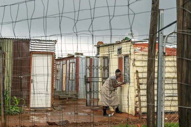 A woman living in the Vlakfontein informal settlement outside Johannesburg, South Africa, shuts her window during a rainstorm, Monday December 13, 2021. South Africa's 7-day rolling average of daily new COVID-19 cases has risen over the past two weeks from 7.60 new cases per 100,000 people on Nov. 28 to 32.71 new cases per 100,000 people on Dec. 12, 2021 according to Johns Hopkins University. In general, the new omicron cases have resulted in milder cases, with fewer hospitalizations and less severe cases requiring oxygen or intensive care. (Photo by Jerome Delay/AP Photo)