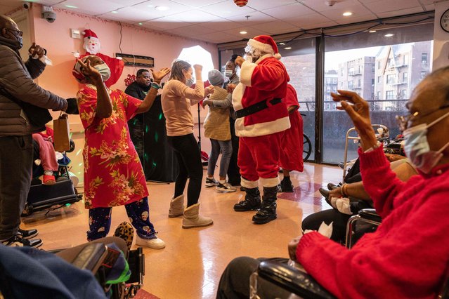 Nursing home residents and staff members dance together during the residents' Christmas party at Crown Heights Center for Nursing and Rehabilitation in Brooklyn, New York on December 24, 2021. (Photo by Yuki Iwamura/AFP Photo)