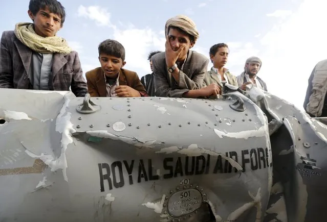 People stand by part of a Saudi fighter jet found in Bani Harith district north of Yemen's capital Sanaa May 24, 2015. (Photo by Khaled Abdullah/Reuters)