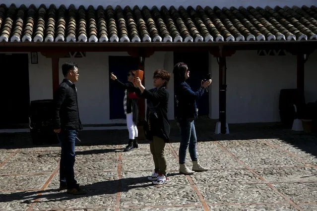 Tourists take pictures at the inn where locals believe Don Quixote might have been knighted in Puerto Lapice, Spain, April 8, 2016. (Photo by Susana Vera/Reuters)