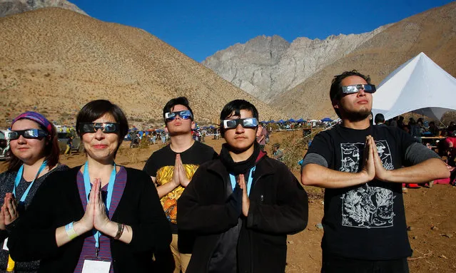 Chileans make the Salute to the Sun prior to a total solar eclipse on July 2, 2019 in Paiguano, Chile. Around 25,0000 tourists arrived to Paiguano, a small town of around 1,000 inhabitants in the Elqui Valley, 650 km away Santiago. This is the only Earth's total solar eclipse of 2019 and the first one since 2017. From this point, the sun will fully disappear for around two minutes. It is best visible from a stripe in the South Pacific, Chile and Argentina. (Photo by Marcelo Hernandez/Getty Images)
