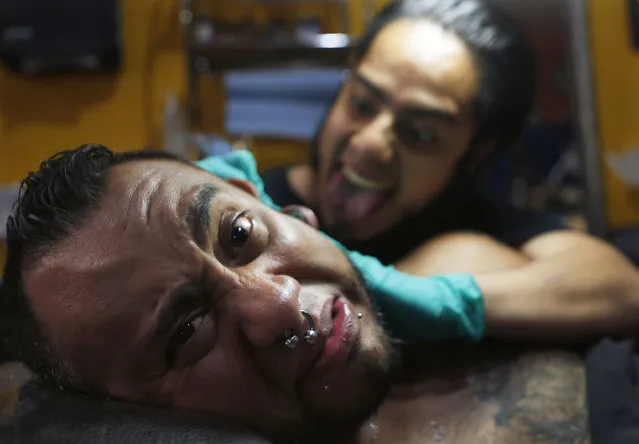 In this April 18, 2019 photo, tattoo artist Lalo Calva inks a tattoo on client Adrian Alonso Rodriguez, a journalist, announcer and dubbing artist, at the Corona Tattoo parlor in Mexico City. Not only inks and techniques have changed in Mexico over the years, but tattoos themselves have evolved from stigmatized symbols of gangs, violence and poverty to an art form. (Photo by Marco Ugarte/AP Photo)
