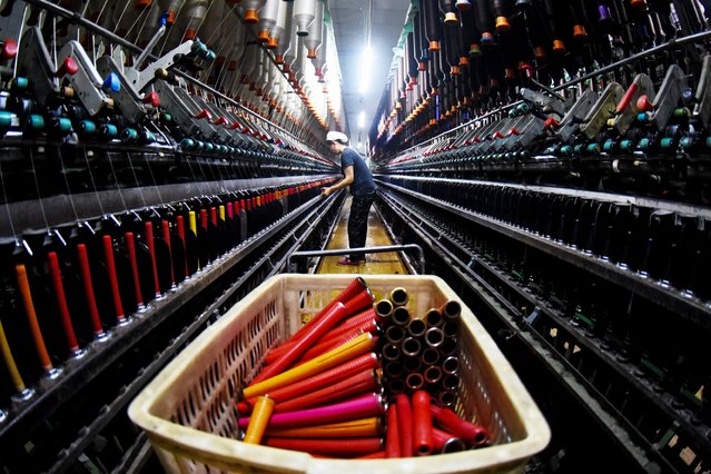 An employee works at a textile factory in Lianyungang, in eastern China's Jiangsu province on May 17, 2024. (Photo by AFP Photo/China Stringer Network)