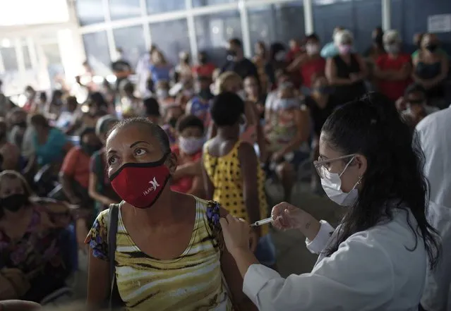 A healthcare worker injects a woman with a dose of the Sinovac COVID-19 vaccine in Sao Joao de Meriti, Rio de Janeiro state, Brazil, Wednesday, April 28, 2021. (Photo by Silvia Izquierdo/AP Photo)