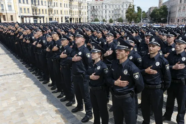 Police officers sing the national anthem during an oath-taking ceremony, which started up the work of a new police patrol service, part of the Interior Ministry reform initiated by Ukrainian authorities, in Kiev, Ukraine, July 4, 2015. The new service, which includes road, metro and foot patrols, is expected to replace the traffic police, widely associated with disrepute and corruption, according to local media. First 2.000 officers took an oath of allegiance to the Ukrainian people on Saturday. (Photo by Valentyn Ogirenko/Reuters)