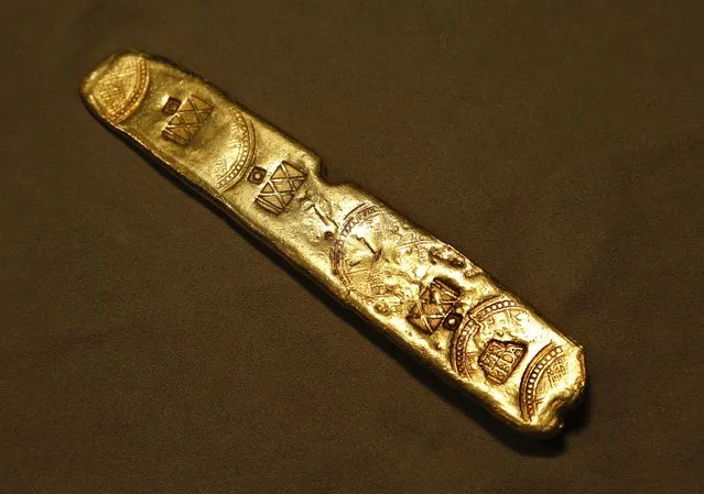 In this June 18, 2015 photo, a gold bar sits on display in New York. The bar, which was just a portion of 40 tons of gold and silver pulled from the 400-year-old Spanish galleon Nuestra Senora de Atocha wreckage, will be one of forty select items from the ship auctioned off by Guernsey's next month. (Photo by Julie Jacobson/AP Photo)