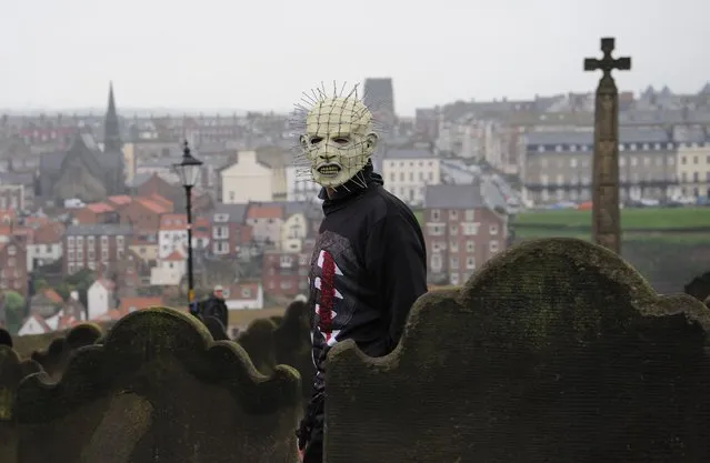 A man wearing a 'Pinhead' mask walks through the grounds of St Mary's Church, Whitby, during the Whitby Gothic festival taking place this weekend, on  April 27, 2014. The twice yearly event attracts Goths from across the UK and beyond to the historic fishing town and is a great boost to the local economy. (Photo by Anna Gowthorpe/PA Wire)