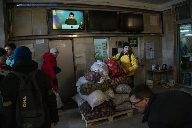Ukrainian volunteers sort donated foods for later distribution to the local population while Ukrainian President Volodymyr Zelenskiy appears on television in Lviv, western Ukraine, Wednesday, March 2, 2022. (Photo by Bernat Armangue/AP Photo)