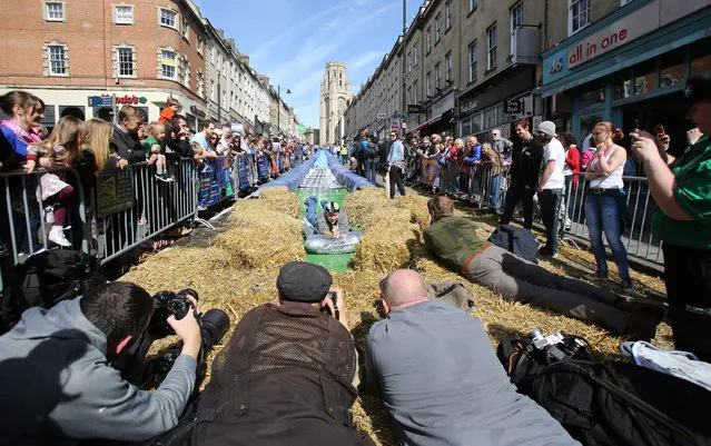 A participant on a lilo slides down a giant water slide that has been installed down Park Street on May 4, 2014 in Bristol, England. (Photo by Matt Cardy/Getty Images)