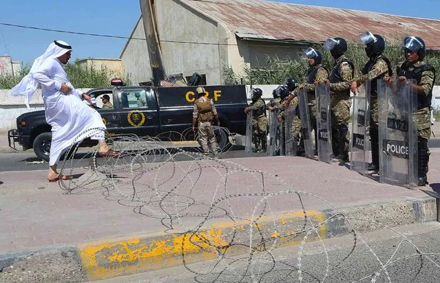 Iraq riot police prevent protesters from breaking into the provincial council building during a demonstration demanding better public services and jobs and against corruption in Basra, southeast of Baghdad, Iraq, Thursday, June 20, 2019. (Photo by Nabil al-Jurani/AP Photo)