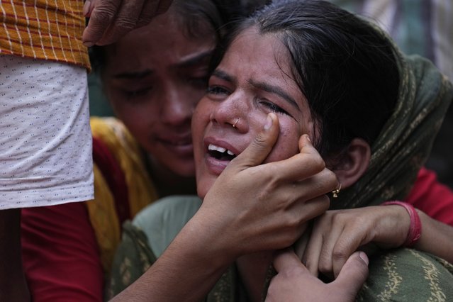 Sonam weeps as the final rites are performed for her mother Savitri Devi, 50, who died during a stampede, in Ramnagar, in the northern Indian state of Uttar Pradesh, Wednesday, July 3, 2024. (Photo by Rajesh Kumar Singh/AP Photo)