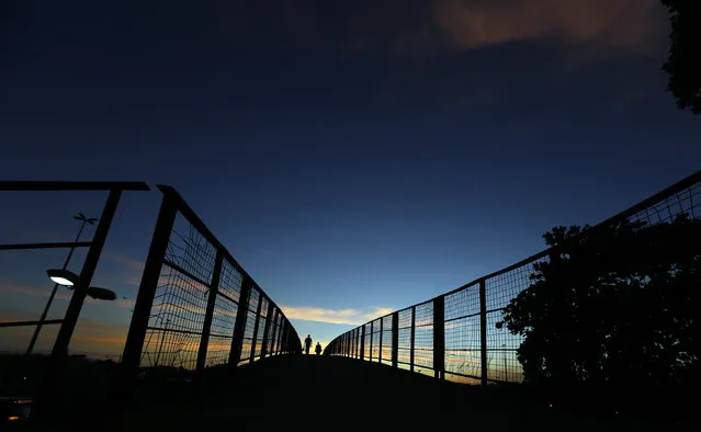 People walk on a catwalk over the Brasil avenue during a 48-hour bus strike in Rio de Janeiro May 13, 2014. The strike renewed concerns about services and public order one month before Rio and 11 other Brazilian cities play host to the upcoming World Cup soccer tournament. (Photo by Sergio Moraes/Reuters)