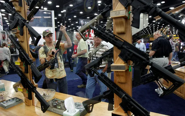 Gun enthusiasts look over Rock River Arms' guns at the National Rifle Association's annual meetings and exhibits show in Louisville, Kentucky, May 21, 2016. (Photo by John Sommers II/Reuters)