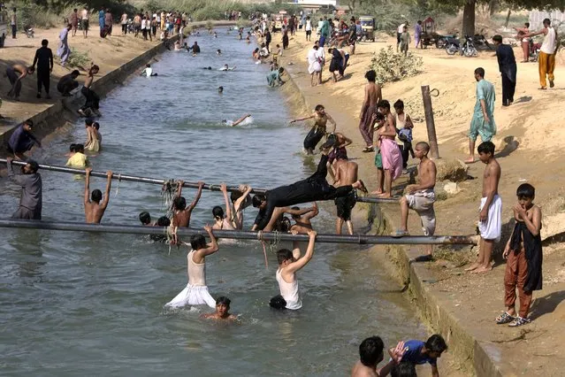 People swim in a canal to cool themselves as temperature reached 37 C (98.6 F) on the outskirts of Karachi, Pakistan, Wednesday, April 6, 2022. (Photo by Fareed Khan/AP Photo)
