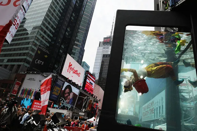 Performance artist Annie Saunders performs in Times Square in Holoscenes, a tank that rapidly fills with water and engulfs the performer, as part of the World Science Festival on May 31, 2017 in New York City. As part of the tenth World Science Festival, Holoscenes developed out of a concern that water from itensifying floods, rising seas, and longer droughts will be a central issue of the 21st century. Holoscenes is performed in a twelve ton glass aquarium and will be performed from 6pm to 11pm, June 1 - 3. (Photo by Spencer Platt/Getty Images)
