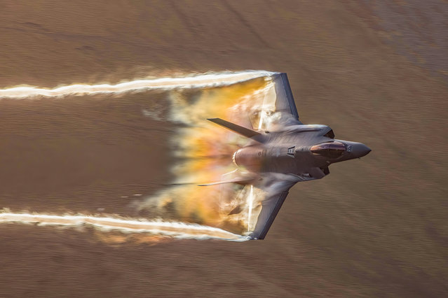 Vapour bounced off the wings of the Lockheed Martin F-35 Lightning II as it sped over the Welsh mountains at a swift 575mph on February 10, 2022. The jet was taking part in a low-level training exercise through the Mach Loop – a series of valleys in North Wales. (Photo by Thomas Winstone/News Images)