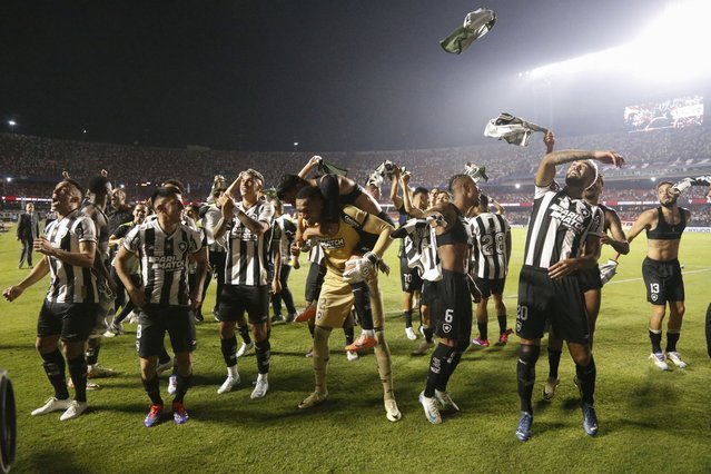 Botafogo players celebrate after winning during the penalty shootout of the Copa Libertadores all-Brazilian quarter-final second leg football match between Sao Paulo and Botafogo, at the Morumbi stadium in Sao Paulo, Brazil, on September 25, 2024. (Photo by Miguel Schincariol/AFP Photo)