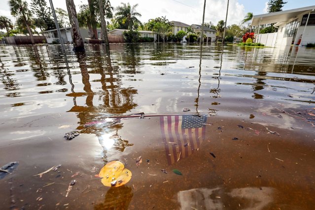 An American flag sits in floodwaters in the aftermath of Hurricane Helene in the Shore Acres neighborhood Friday, September 27, 2024, in St. Petersburg, Fla. Helene has reportedly killed at least 20 people and inflicted more than 4m power outages across the south-eastern US after crashing ashore in north-western Florida late on Thursday as a potent category 4 hurricane, according to officials.(Photo by Mike Carlson/AP Photo)