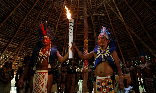 Indigenous people take part in the Olympic Flame torch relay at village Tupe, in Manaus, Amazonas state, Brazil, June 20, 2016. (Photo by Bruno Kelly/Reuters)