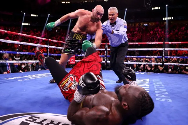 Deontay Wilder (C) is knocked down by Tyson Fury in the third round of their WBC heavyweight title fight at T-Mobile Arena on October 09, 2021 in Las Vegas, Nevada. (Photo by Al Bello/Getty Images)
