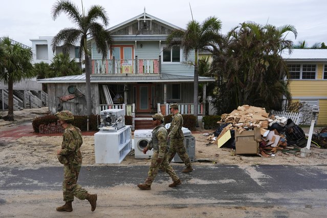 Members of the Florida Army National Guard check for any remaining residents in nearly-deserted Bradenton Beach, where piles of debris from Hurricane Helene flooding still sits outside damaged homes ahead of the arrival of Hurricane Milton, Tuesday, October 8, 2024, on Anna Maria Island, Fla. (Photo by Rebecca Blackwell/AP Photo)