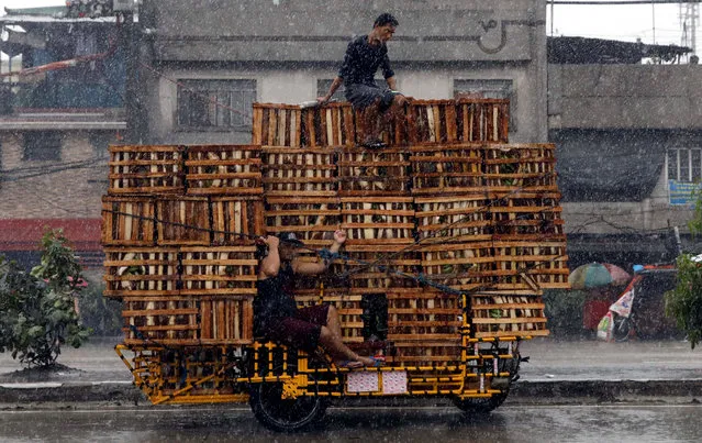 Vendors ride on a vehicle transporting crates containing bananas in Malabon, Metro Manila, Philippines July 26, 2017. (Photo by Erik De Castro/Reuters)