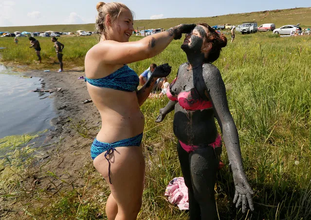 Tourists cover themselves with mineral-rich mud as they rest on a bank of Tus lake, with the air temperature at about 32 degrees Celsius (89.6 degrees Fahrenheit), in the Republic of Khakassia, Russia, July 27, 2017. (Photo by Ilya Naymushin/Reuters)