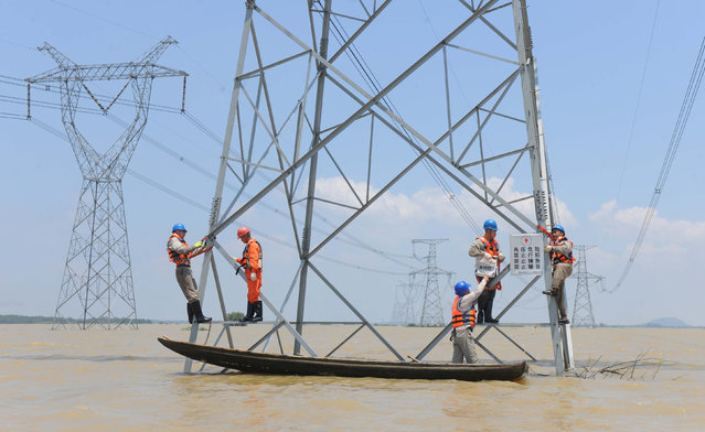 Workers reinforce the electric pylons at a flooded area as Typhoon Nepartak approaches in Xuancheng, Anhui Province, China, July 9, 2016. (Photo by Reuters/Stringer)