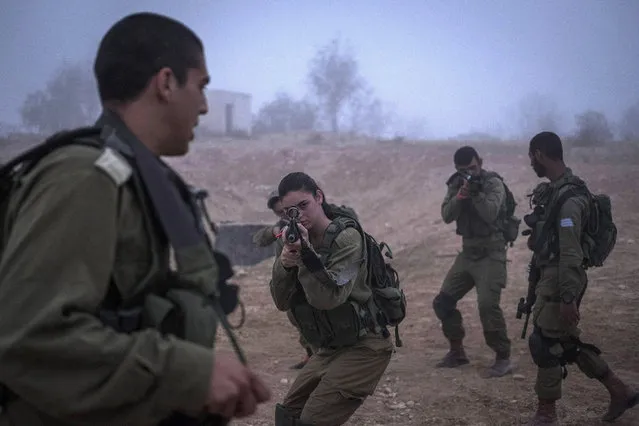 A female soldier takes aim as Israeli male and female combat soldiers of the Bardales battalion take part in a long day of practise in a heavy fog on July 13, 2016 in Nitzana, Israel. Bardales battalion is a new mixed-gender combat battalion that has been active since 2015. (Photo by Ilia Yefimovich/Getty Images)