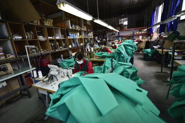 Volunteer workers in a clothing factory manufacturing firefighting gear, make hospital gowns for medical staff to protect them from the coronavirus, in Arnedo, northern Spain, Monday, March 30, 2020. (Photo by Alvaro Barrientos/AP Photo)