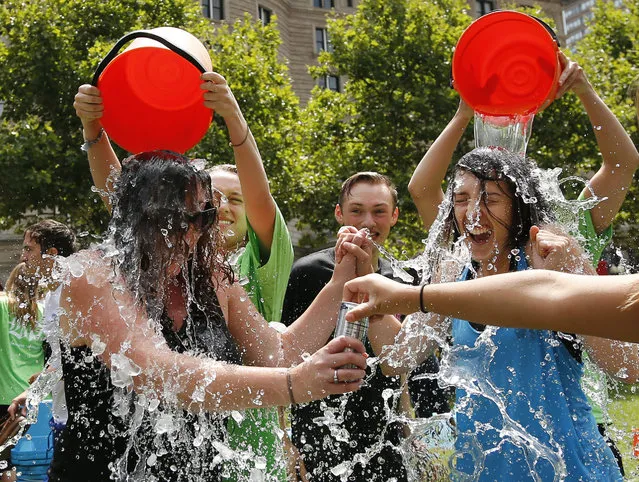 In this August 7, 2014, file photo, two women get doused during the ice bucket challenge at Boston's Copley Square to raise funds and awareness for ALS. The ALS Association says money raised through the challenge helped fund a project that has discovered a gene linked to the disease. (Photo by Elise Amendola/AP Photo)