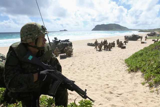 A soldier with the Japan Maritime Self-Defense Force sets up a perimeter defense during a simulated beach assault at Marine Corps Base Hawaii with the 3rd Marine Expeditionary Unit during the multi-national military exercise RIMPAC in Kaneohe, Hawaii, July 30, 2016. (Photo by Hugh Gentry/Reuters)