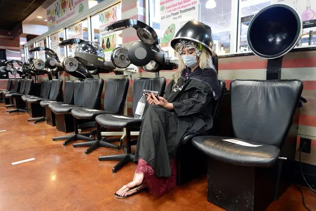 Jessica King sits under a dryer at Three-13 Salon, Spa and Boutique, during the phased reopening of businesses and restaurants from coronavirus disease (COVID-19) restrictions in the state, in Marietta, Georgia, U.S., April 24, 2020. (Photo by Bita Honarvar/Reuters)