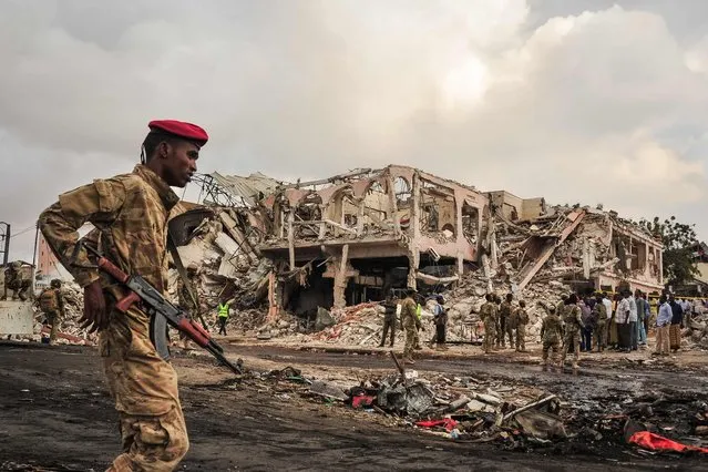 Somali soldiers patrol on the scene of the explosion of a truck bomb in the centre of Mogadishu, on October 15, 2017. (Photo by Mohamed Abdiwahab/AFP Photo)